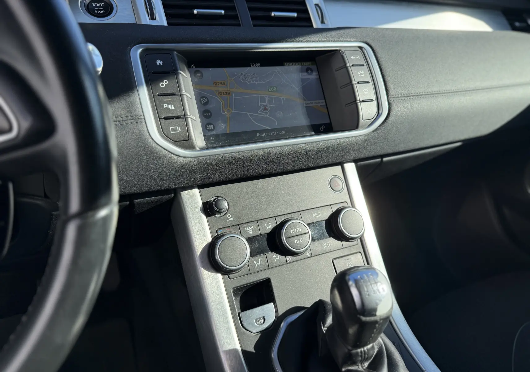 Vue rapprochée de la console centrale grise du Range Rover Evoque 2017 avec écran tactile et commandes climatisation.