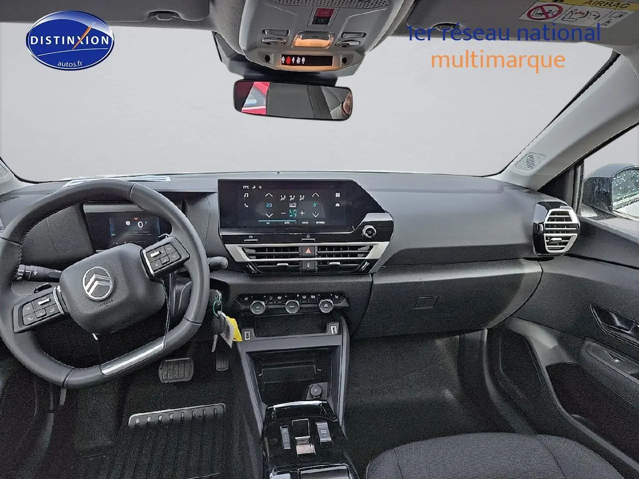 Intérieur noir du Citroën C4 1.2 hybride 136 plus 2025 vu de face, avec écran tactile et volant multifonction.