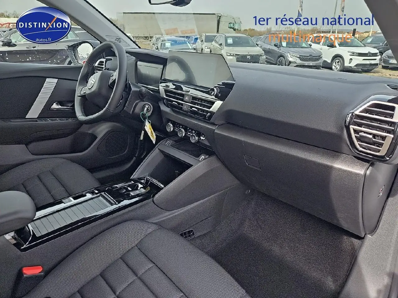 Intérieur noir de la Citroën C4 1.2 hybride 136 plus 2025, vue côté passager avec tableau de bord moderne et écran tactile central.