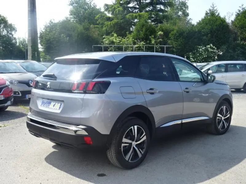 Peugeot 3008 gris clair vue 3/4 arrière droit, jantes alliage 18 pouces et vitres arrière surteintées.