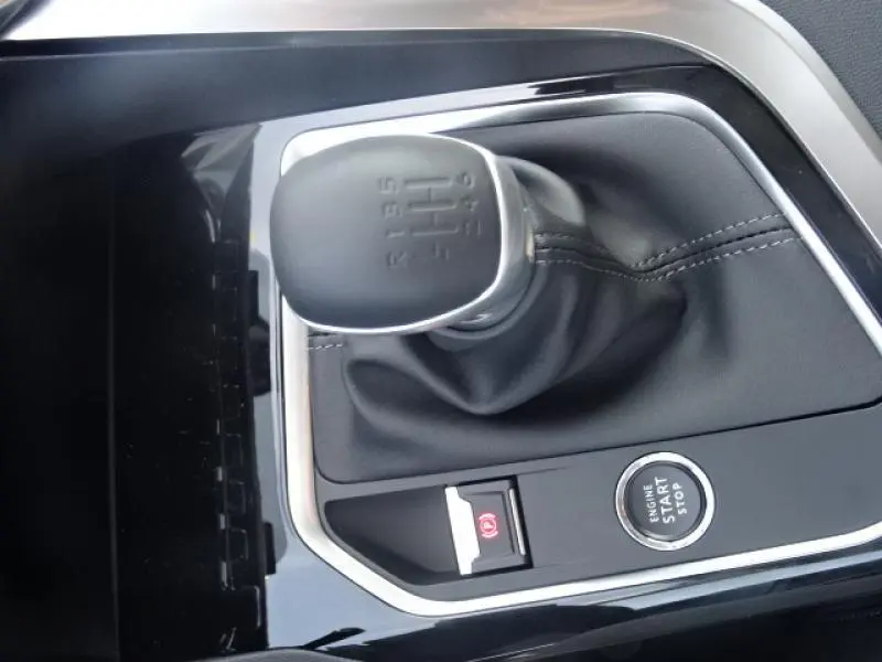 Le levier de vitesse manuel noir du Peugeot 3008 gris clair 2019 avec bouton start/stop et frein à main électrique.