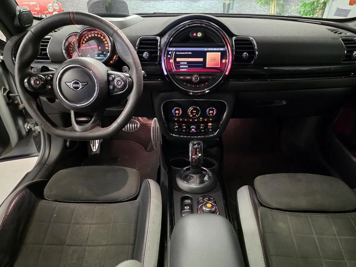 Vue intérieure avant de la MINI Clubman John Cooper Works 2020, sièges sport noirs et tableau de bord avec écran central lumineux.