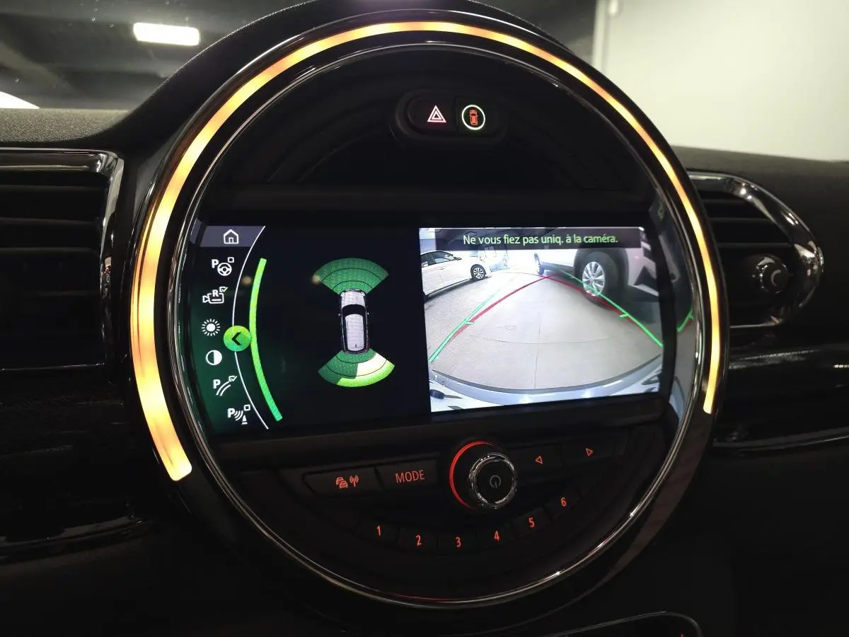 Affichage de la caméra de recul et des capteurs de stationnement sur l'écran central du tableau de bord d'une MINI Clubman gris Moonwalk.