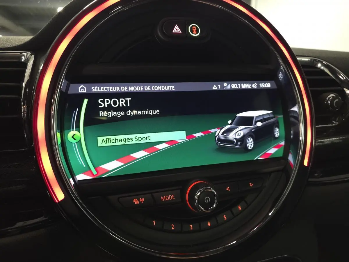 Écran central rond MINI Clubman 2020 affichant le mode de conduite Sport avec éclairage LED orange autour.