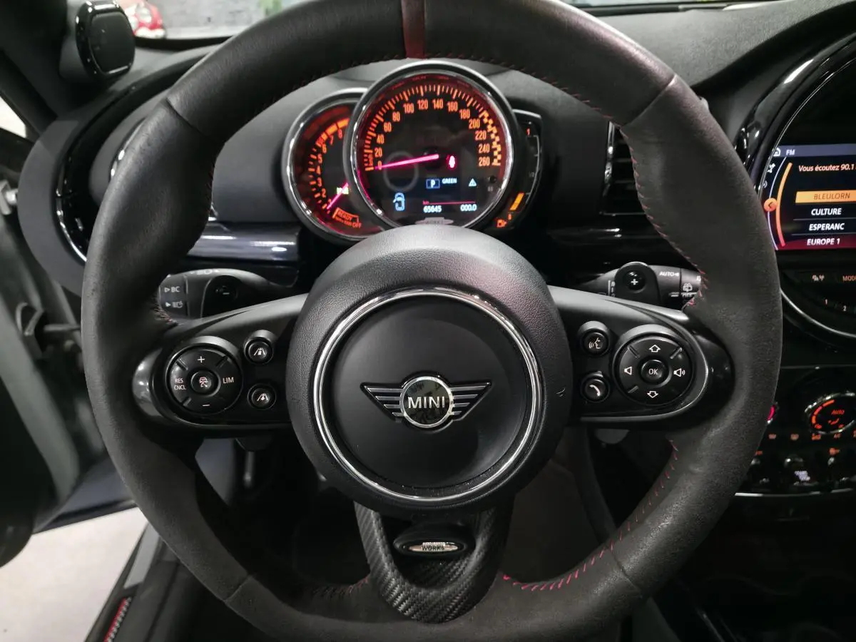 Vue rapprochée du volant sport John Cooper Works en cuir noir avec tableau de bord et commandes du MINI Clubman gris 2020.