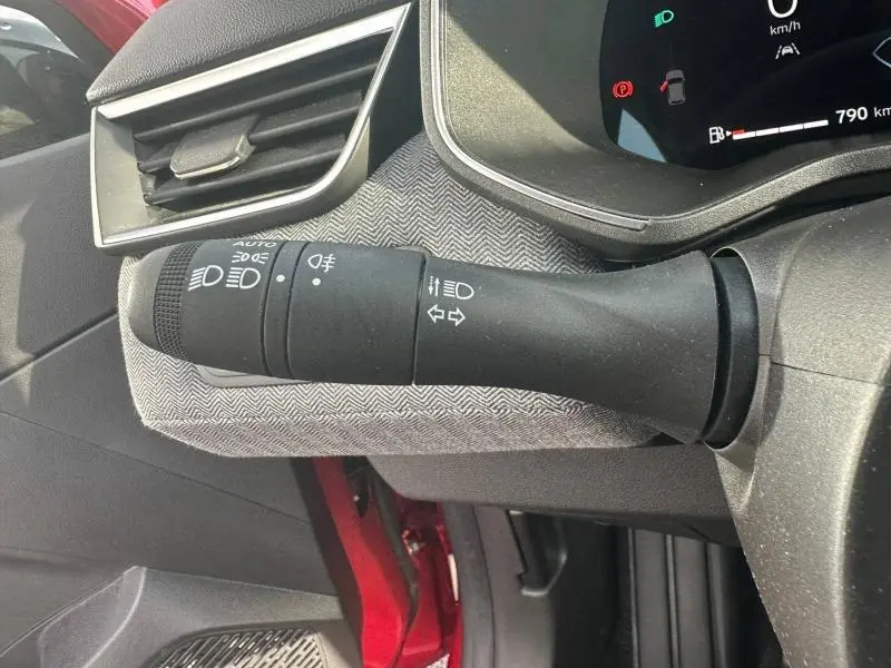 Gros plan sur la commande des feux et clignotants côté gauche du tableau de bord de la Renault Clio Rouge Flamme 2025.