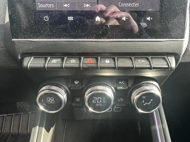 Vue rapprochée du tableau de bord de la Renault Clio 2025, montrant les commandes de climatisation et les boutons de fonction.