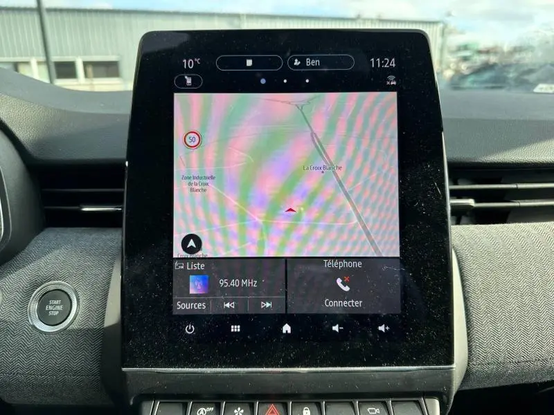 Écran tactile central du tableau de bord de la Renault Clio 2025 affichant la navigation et la radio.