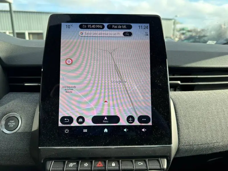 Écran tactile central de la Renault Clio 2025 affichant la navigation avec carte et commandes intégrées.