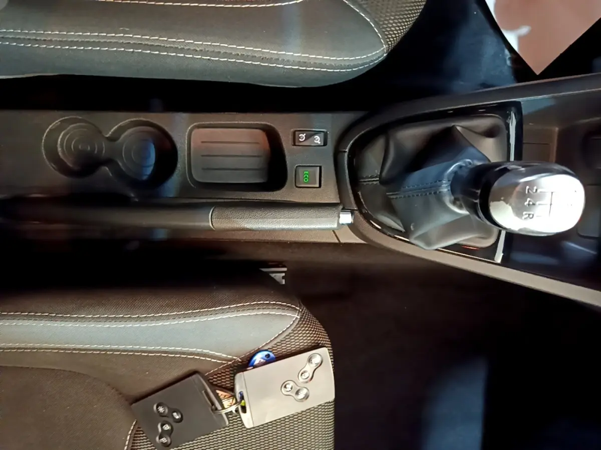 Vue intérieure centrée sur la console centrale noire de la Renault Clio Zen Energy dCi 75 avec levier de vitesse manuel et clé smart card.