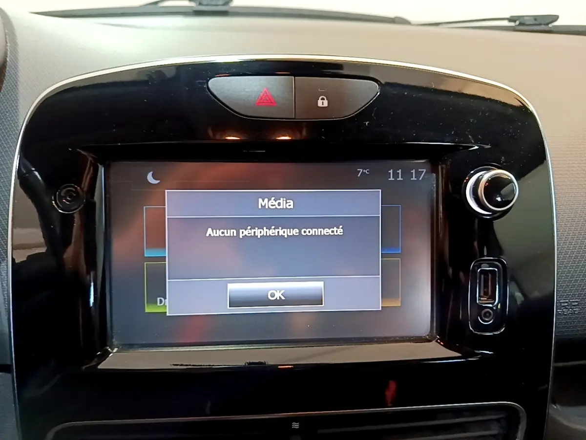 Vue rapprochée de l’écran tactile multimédia noir brillant du tableau de bord de la Renault Clio blanche Zen Energy dCi 75.