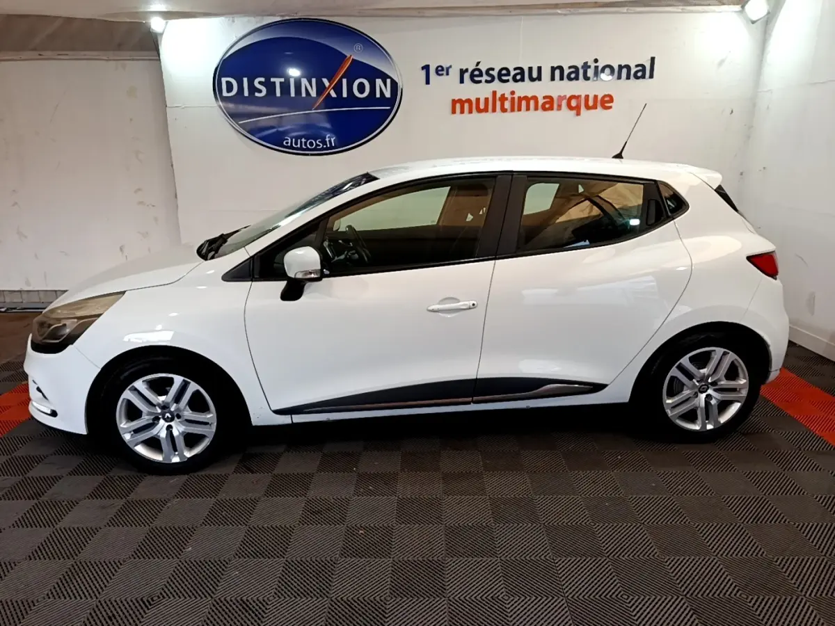 Profil côté gauche d'une Renault Clio Zen Energy dCi 75 blanche, avec jantes alliage et rétroviseurs assortis.