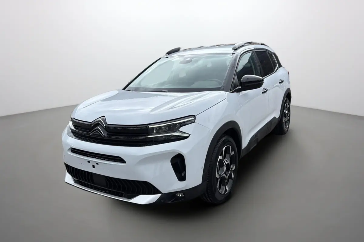 Vue 3/4 avant d'un Citroën C5 Aircross Hybrid blanc okénite avec barres de toit et jantes alu 18 pouces.