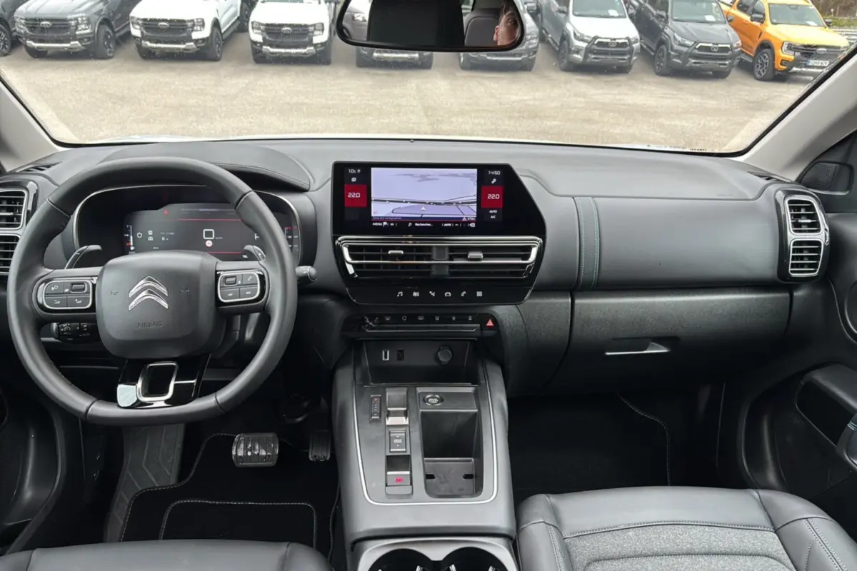 Vue intérieure avant du Citroën C5 Aircross Hybrid blanc, avec tableau de bord numérique et écran tactile central.