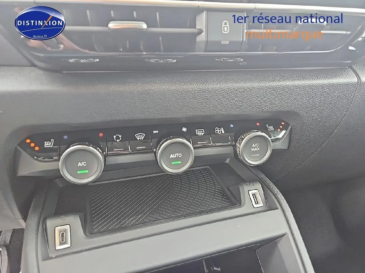 Vue rapprochée de la console centrale de la Citroën C4 bleu eclipse, montrant les commandes de climatisation et prises USB.