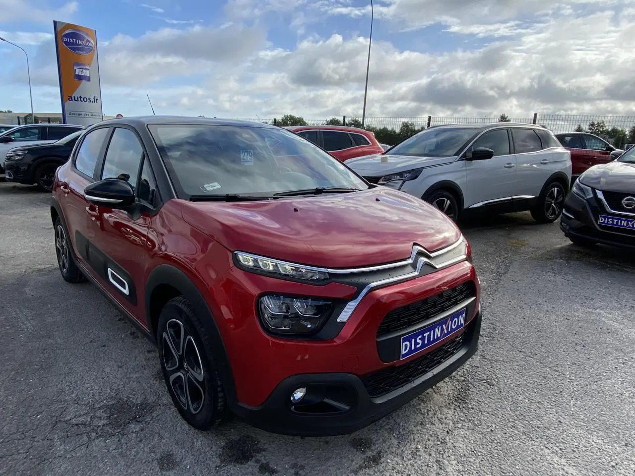 Citroën C3 rouge Elixir en 3/4 avant droit avec toit noir et protections latérales noires distinctives.