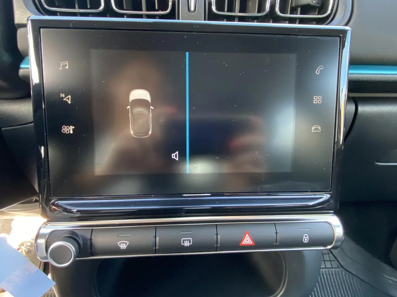 Écran tactile central du tableau de bord de la Citroën C3 noire 2021, avec commandes climatisation et alertes visibles.