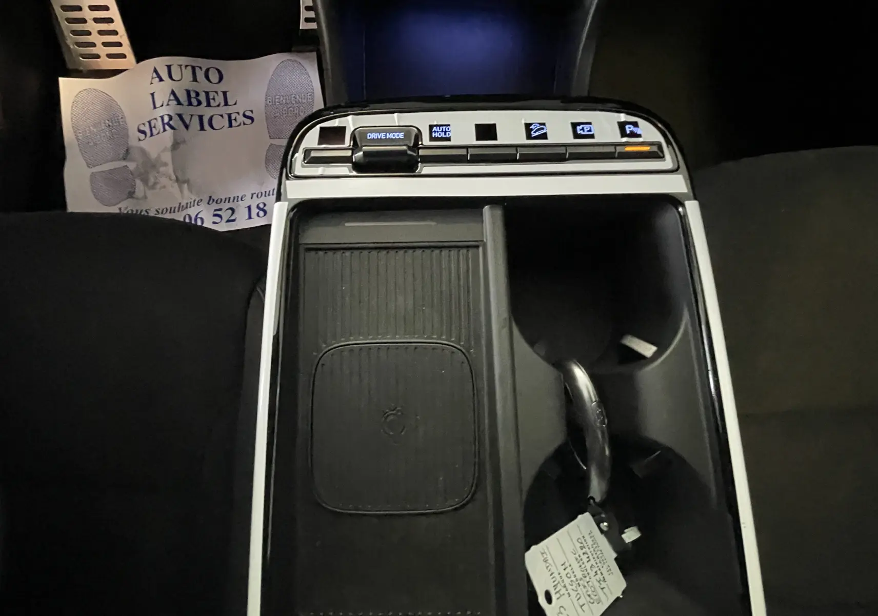 Vue plongeante sur la console centrale noire du Hyundai Tucson 2025, avec commandes tactiles et porte-gobelets.