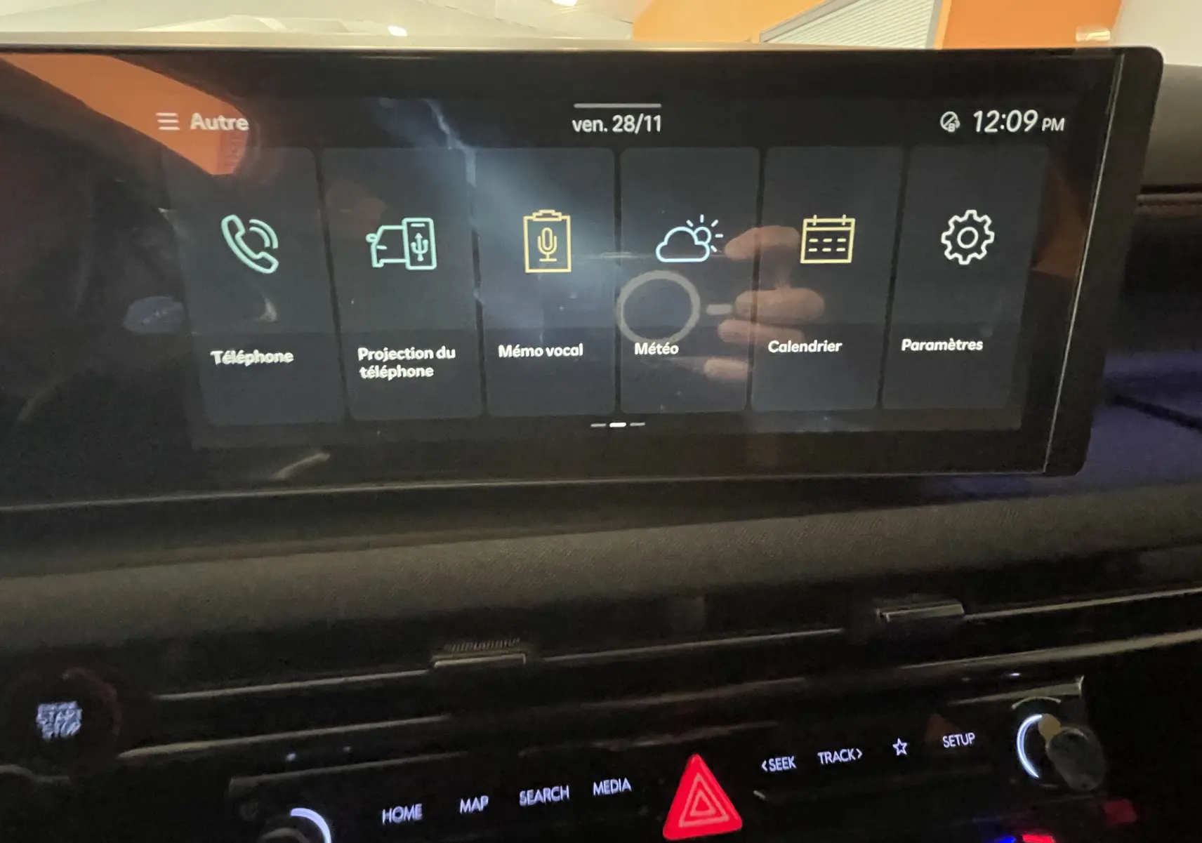 Écran tactile central du Hyundai Tucson 2025 affichant les options téléphone, météo et calendrier dans un intérieur sombre.