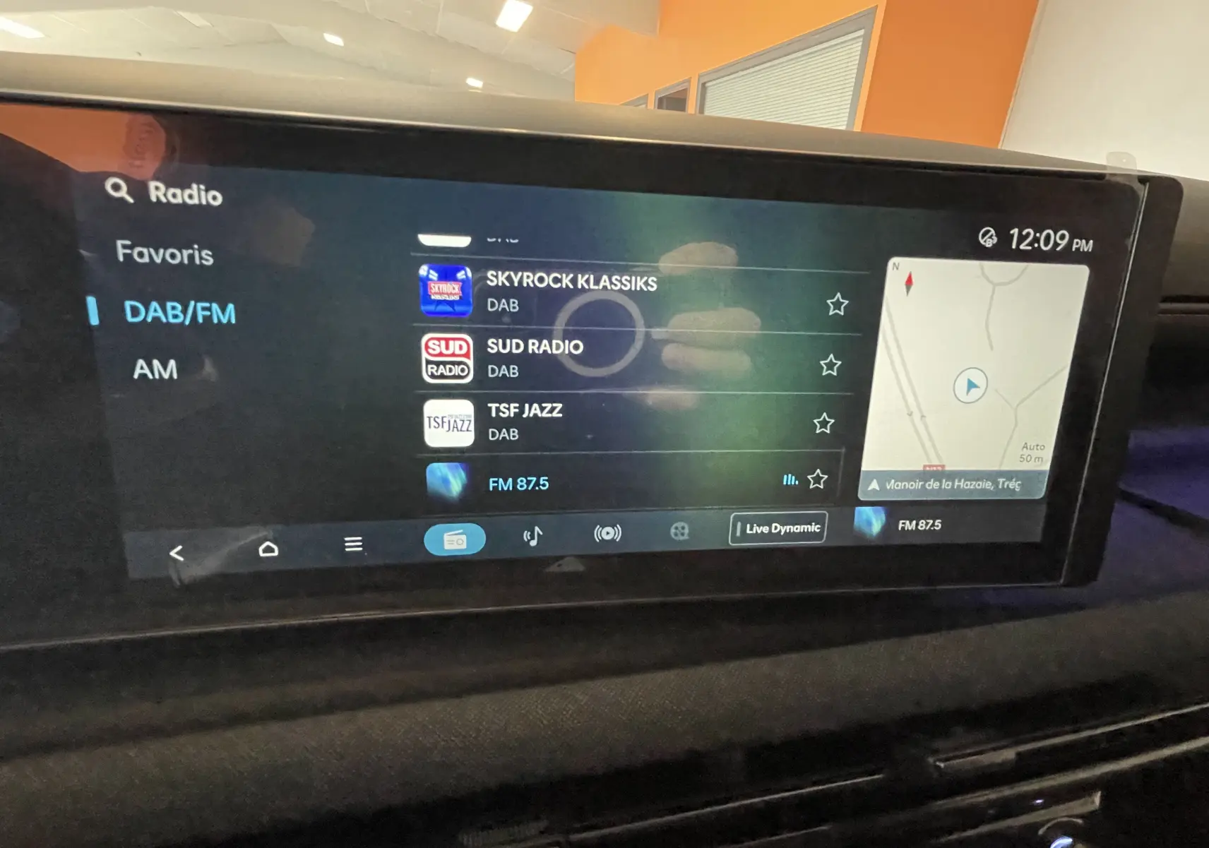 Écran tactile central du Hyundai Tucson 2025 affichant les stations radio DAB/FM avec navigation GPS intégrée.