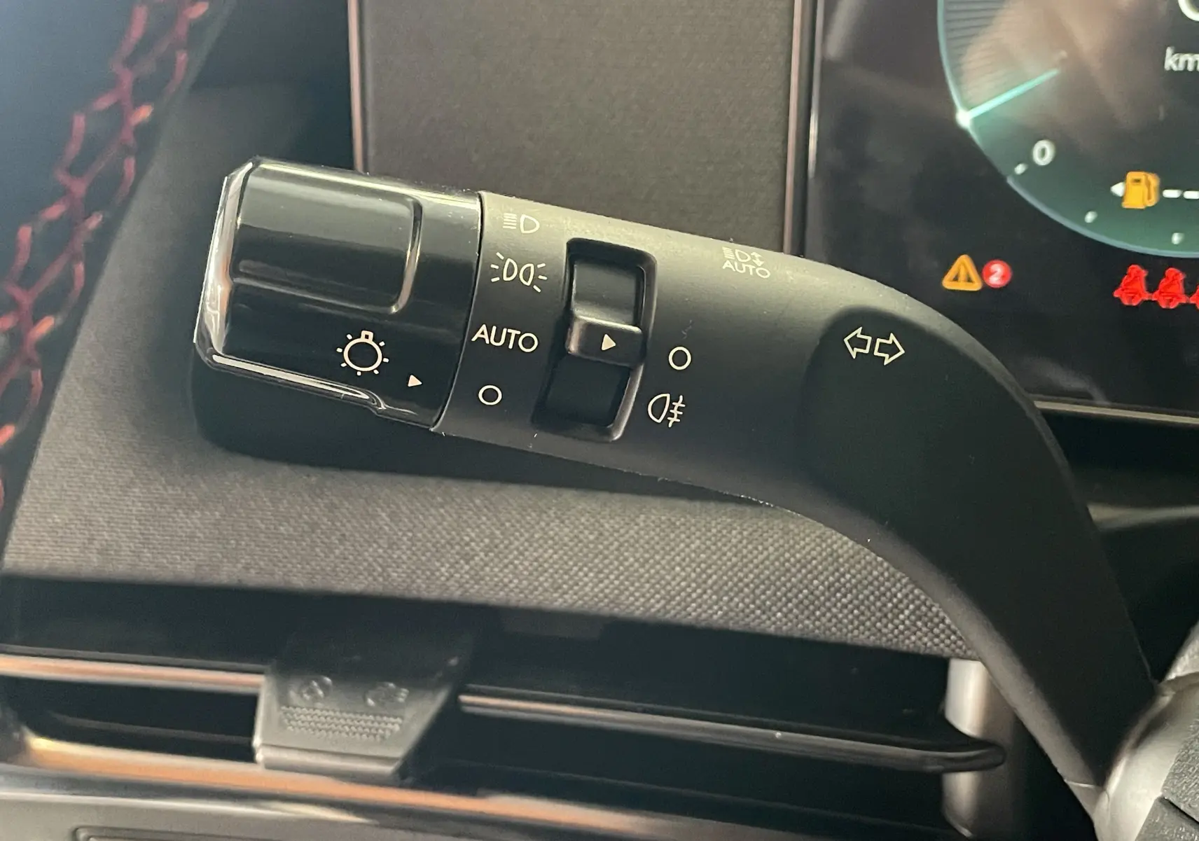 Gros plan sur la manette de clignotants noire avec commandes d'éclairage du Hyundai Tucson gris Ecotronic 2025.
