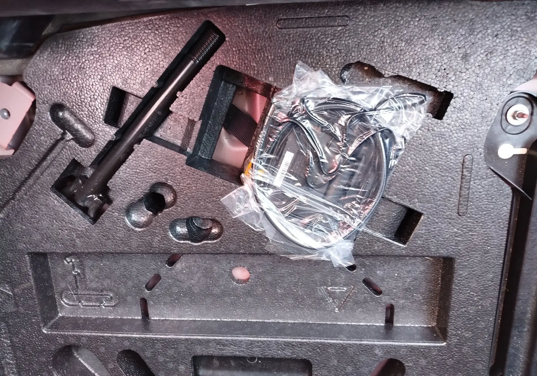 Rangement en mousse noire dans le coffre d’une Renault Clio 1.6 E-Tech avec outils et câble emballé visible.