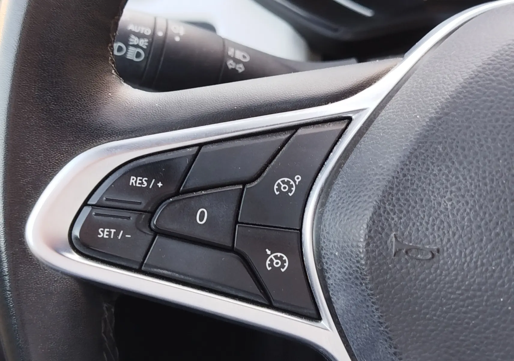 Gros plan sur les commandes de régulateur de vitesse au volant d'une Renault Clio 1.6 E-Tech hybride 2022.
