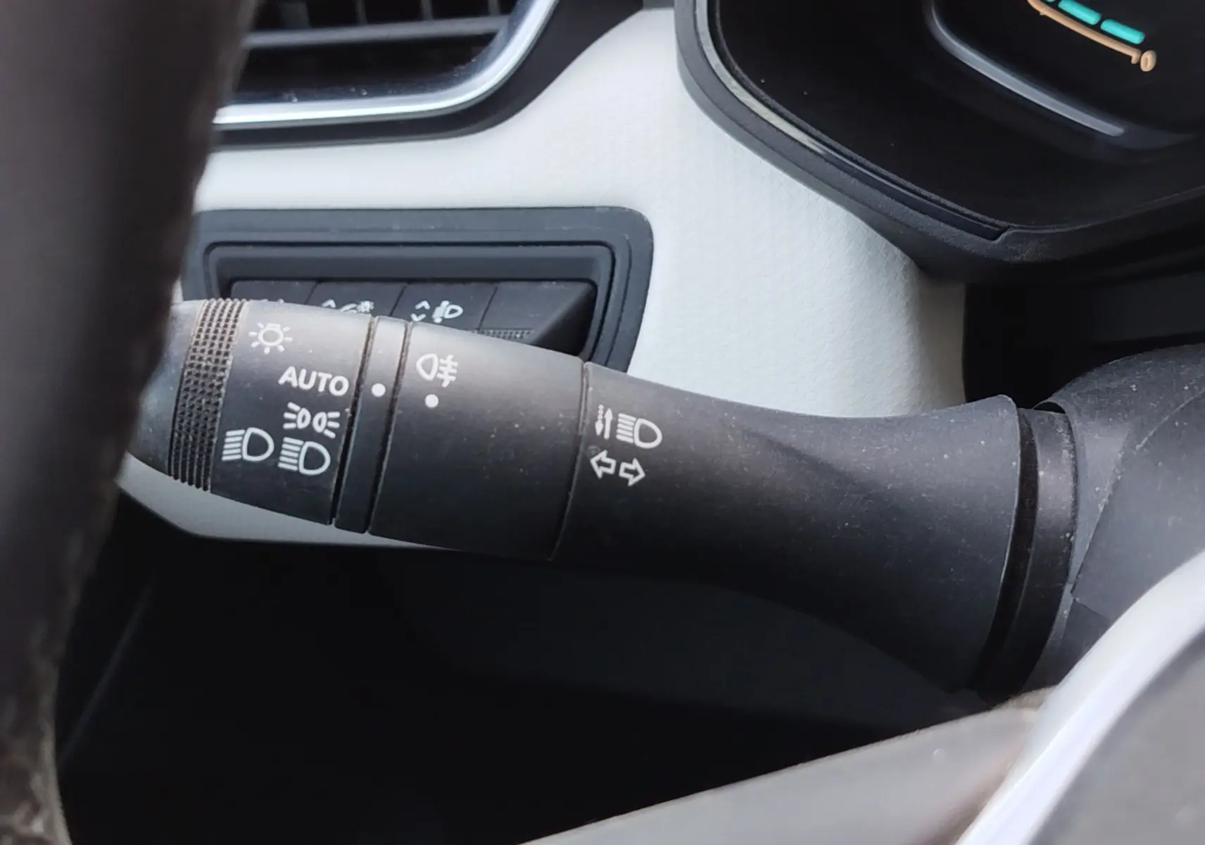 Gros plan sur la commande des phares et clignotants à gauche du volant dans l’habitacle de la Renault Clio orange Valencia.