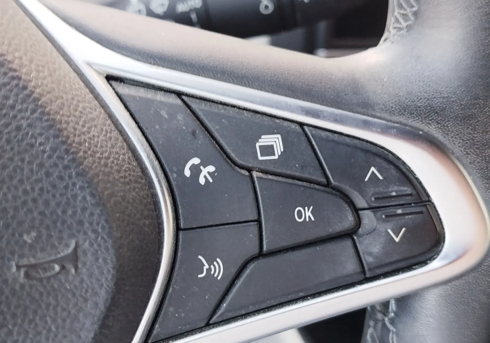 Gros plan sur les commandes multifonctions côté droit du volant d’une Renault Clio 1.6 E-Tech hybride 2022, finition noire.