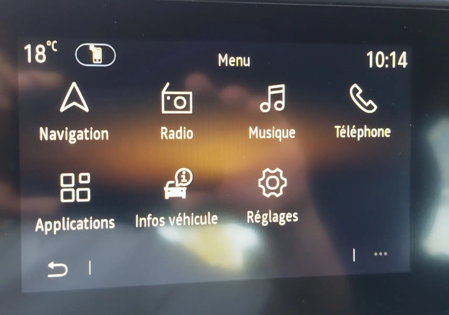 Écran tactile central de la Renault Clio 1.6 E-Tech hybride affichant le menu principal avec navigation et radio.