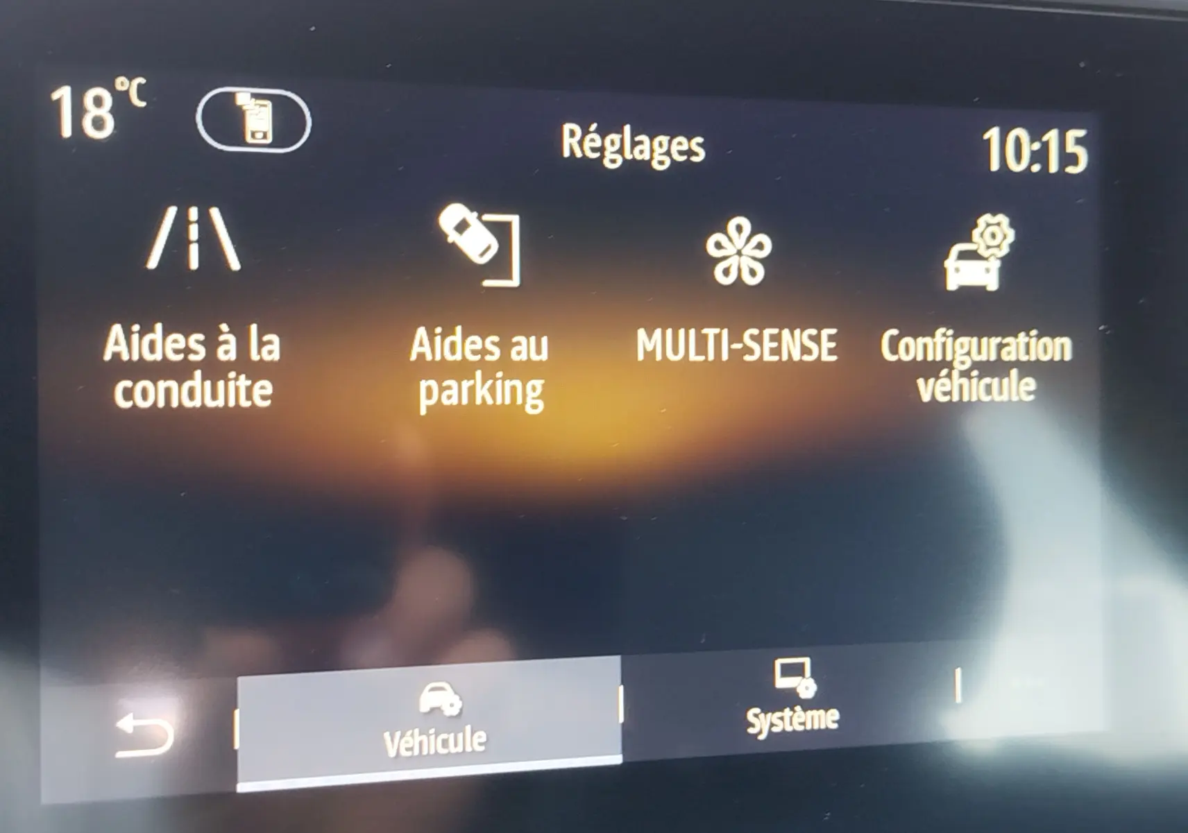 Écran tactile intérieur de la Renault Clio 1.6 E-Tech hybride 2022 affichant les réglages d’aides à la conduite et parking.