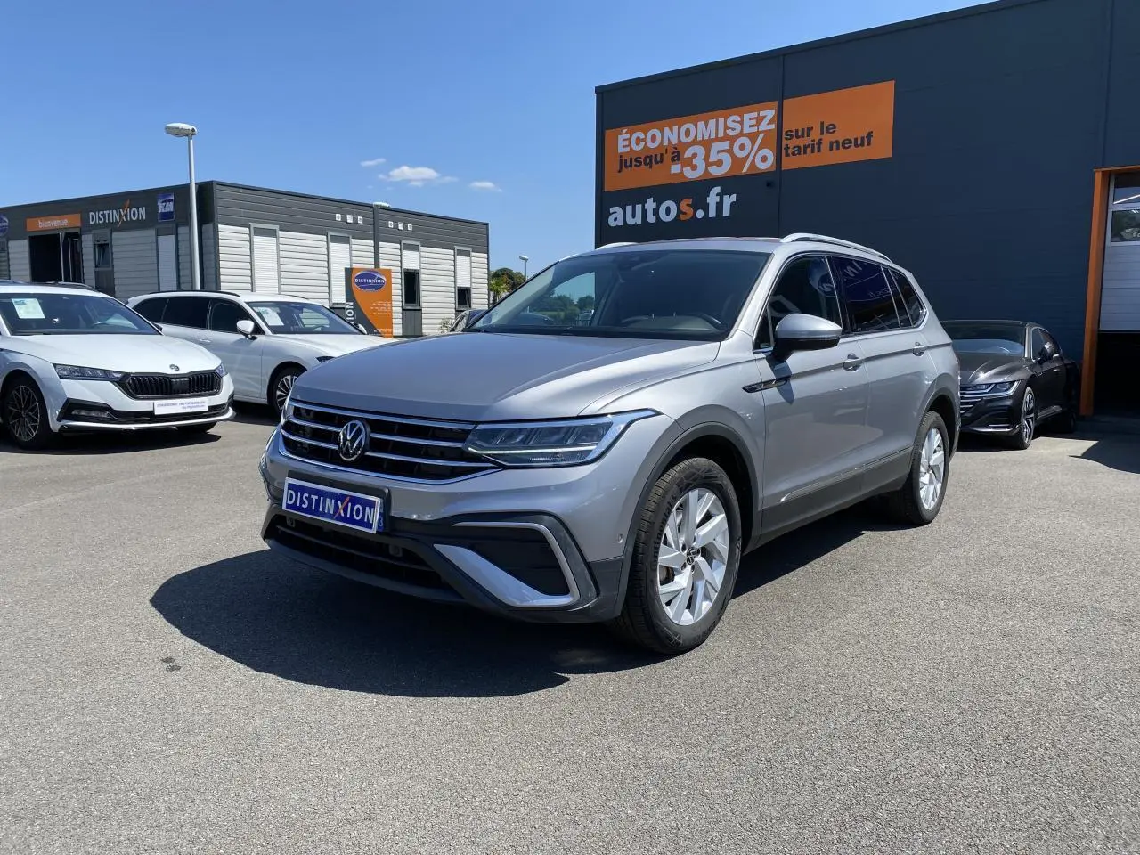 Volkswagen Tiguan Allspace gris argent pyrite métallisé vu en 3/4 avant droit sur parking extérieur.