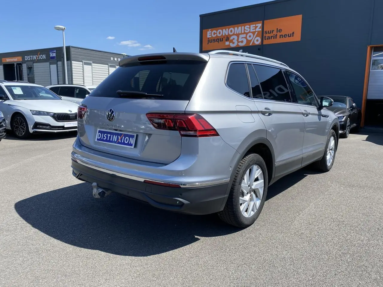 Volkswagen Tiguan Allspace gris argent pyrite métallisé vu en 3/4 arrière droit avec crochet d'attelage escamotable.