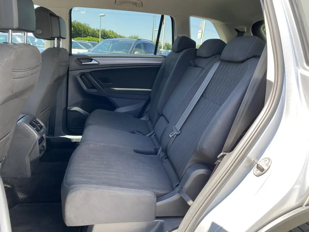 Vue intérieure côté droit des sièges arrière en tissu noir du Volkswagen Tiguan Allspace gris argent Pyrite métallisé.