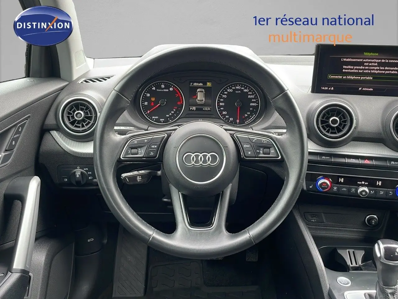 Vue centrée sur le volant et le tableau de bord de l'Audi Q2 noir Mito Metal avec affichage digital et commandes au volant.