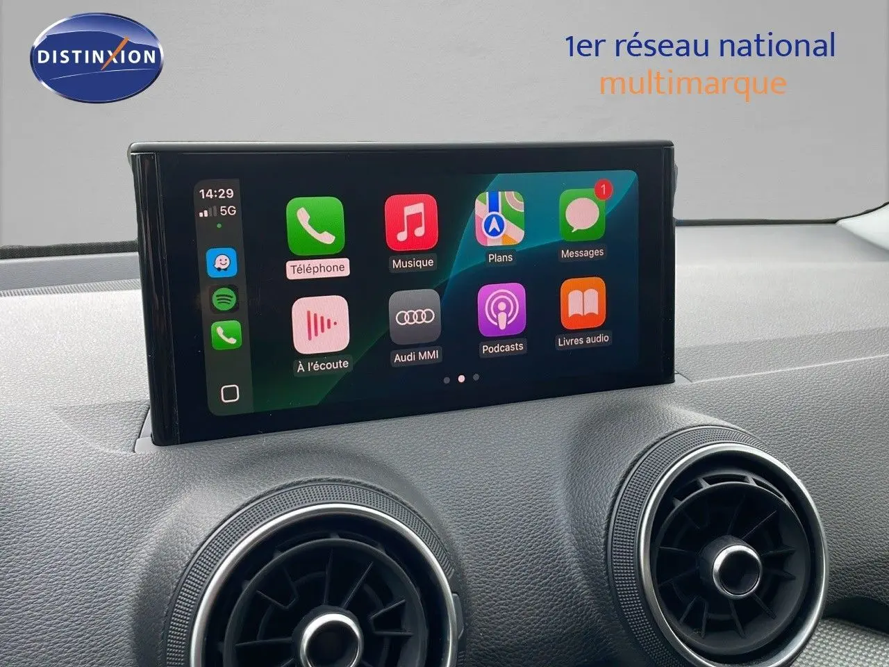 Écran tactile central affichant les applications Apple CarPlay sur le tableau de bord d’un Audi Q2 noir 2023.