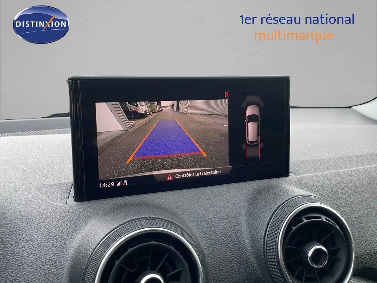 Écran central affichant la caméra de recul et l'aide au stationnement de l'Audi Q2 noir mito metal, vue intérieure du tableau de bord.