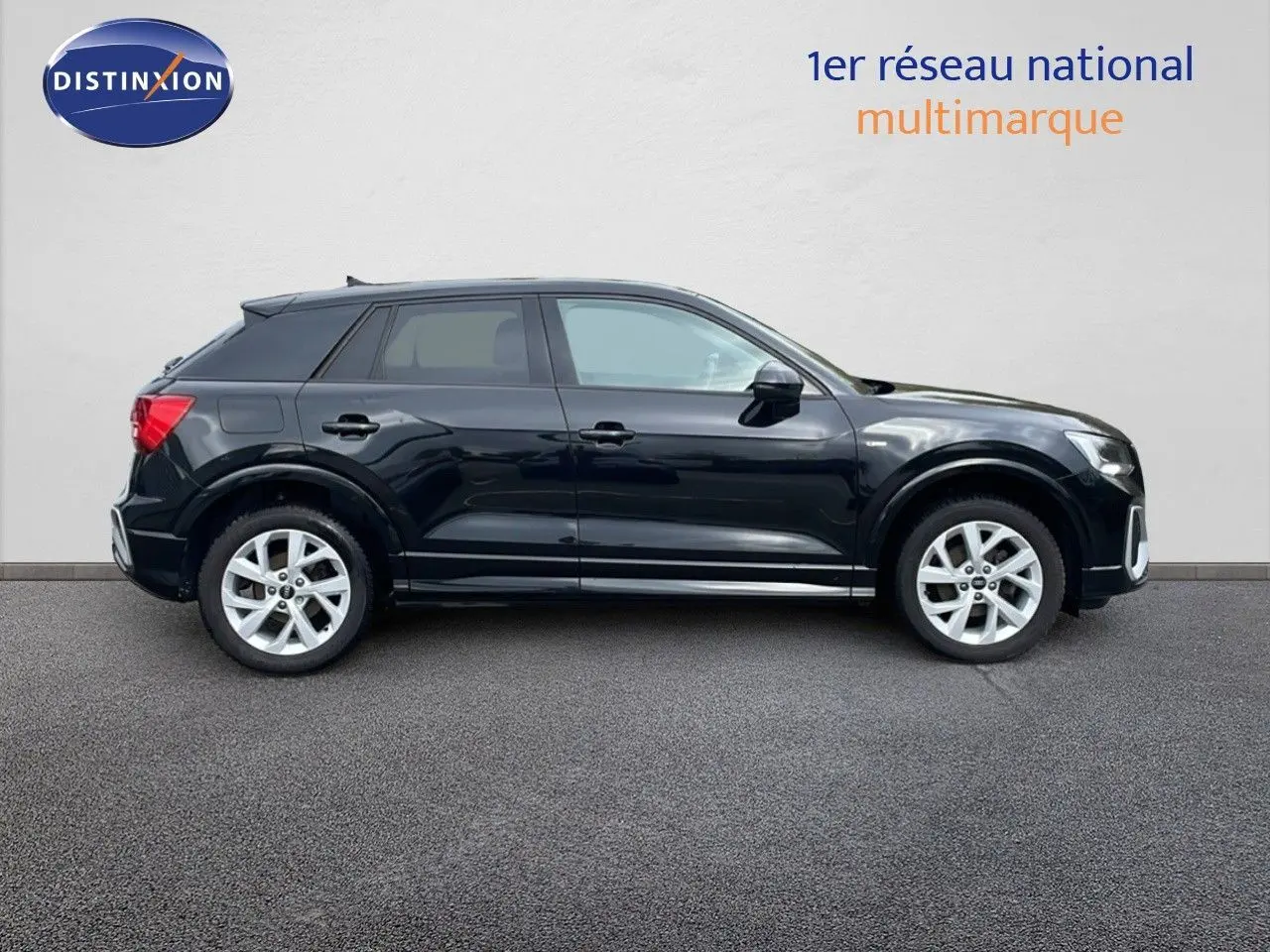 Profil côté gauche d'un Audi Q2 35 TFSI S-Line noir mito metal, avec jantes argentées et lignes dynamiques.