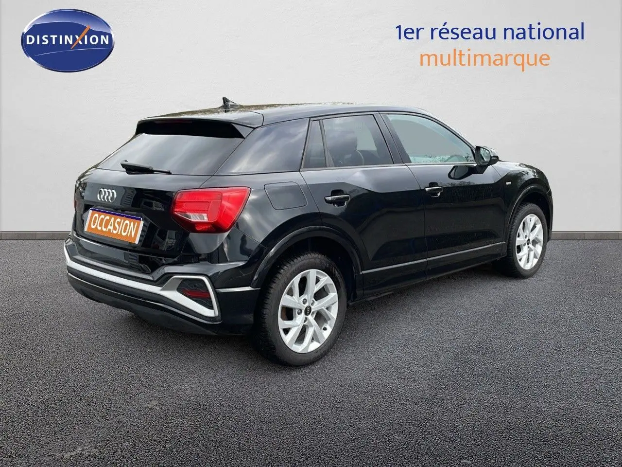 Audi Q2 noir mito metal vue 3/4 arrière côté droit, avec jantes argentées et feux arrière rouges visibles.