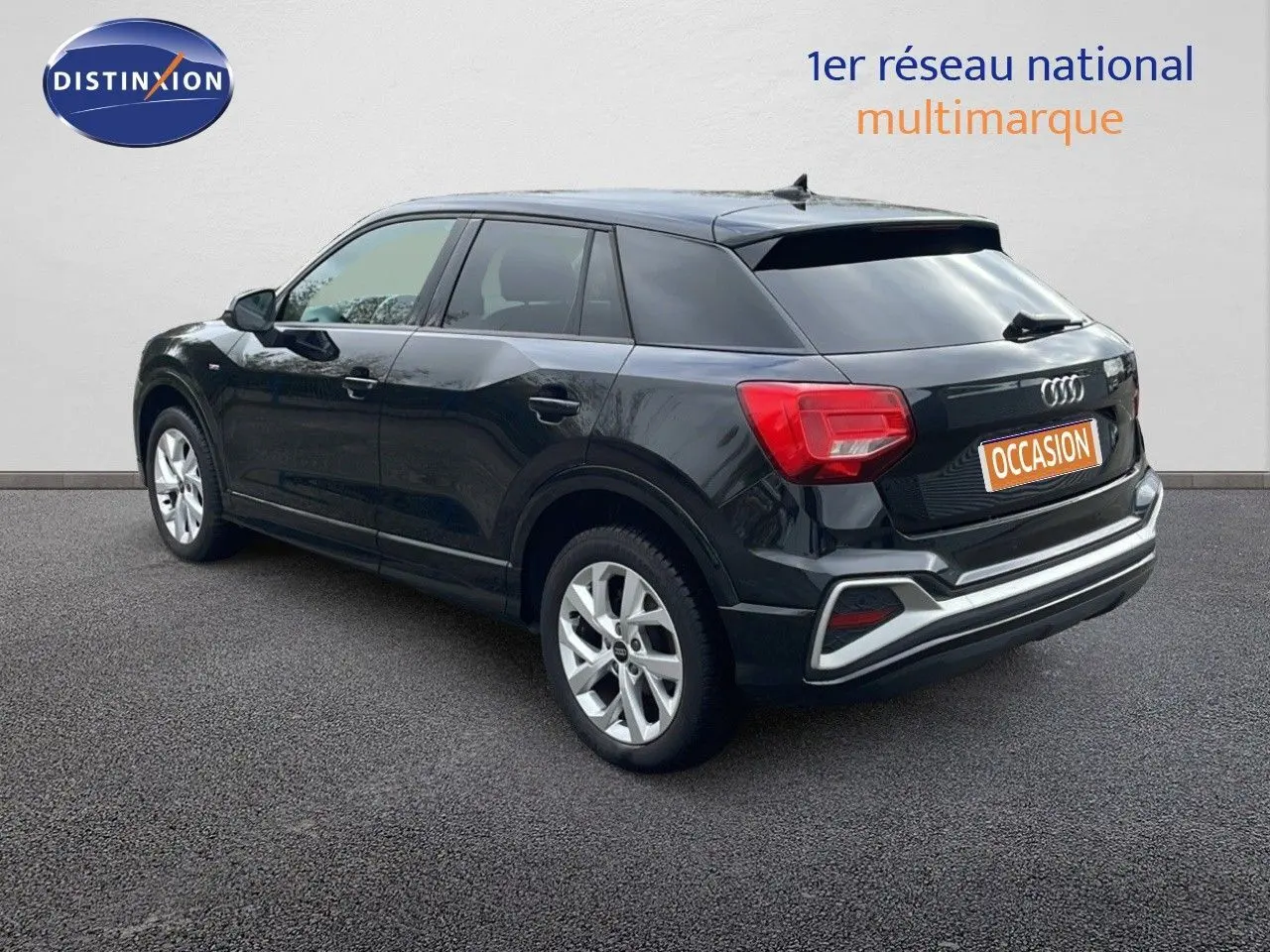 Audi Q2 noir mito metal en 3/4 arrière droit, soulignant ses feux arrière rouges et ses jantes argentées.