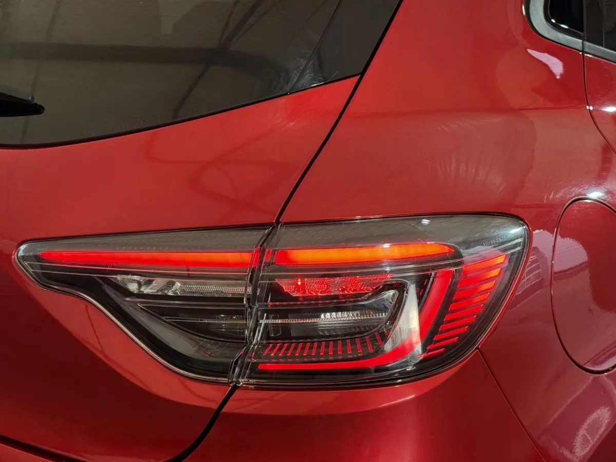 Gros plan sur le feu arrière droit rouge d’une Renault Clio Techno TCe 90 2024 rouge, avec détails lumineux modernes.