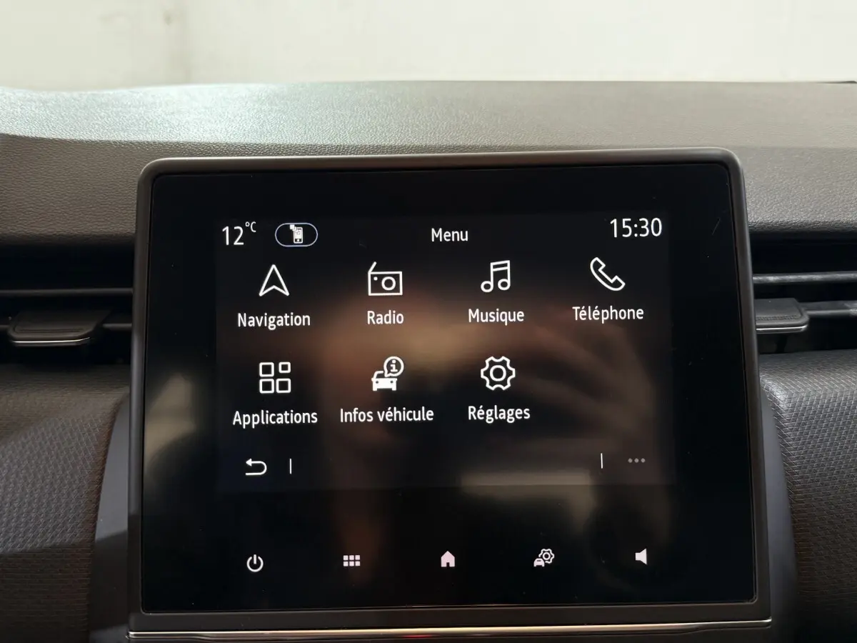 Écran tactile central de la Renault Clio Business blanc 2021 affichant le menu principal avec navigation et musique.