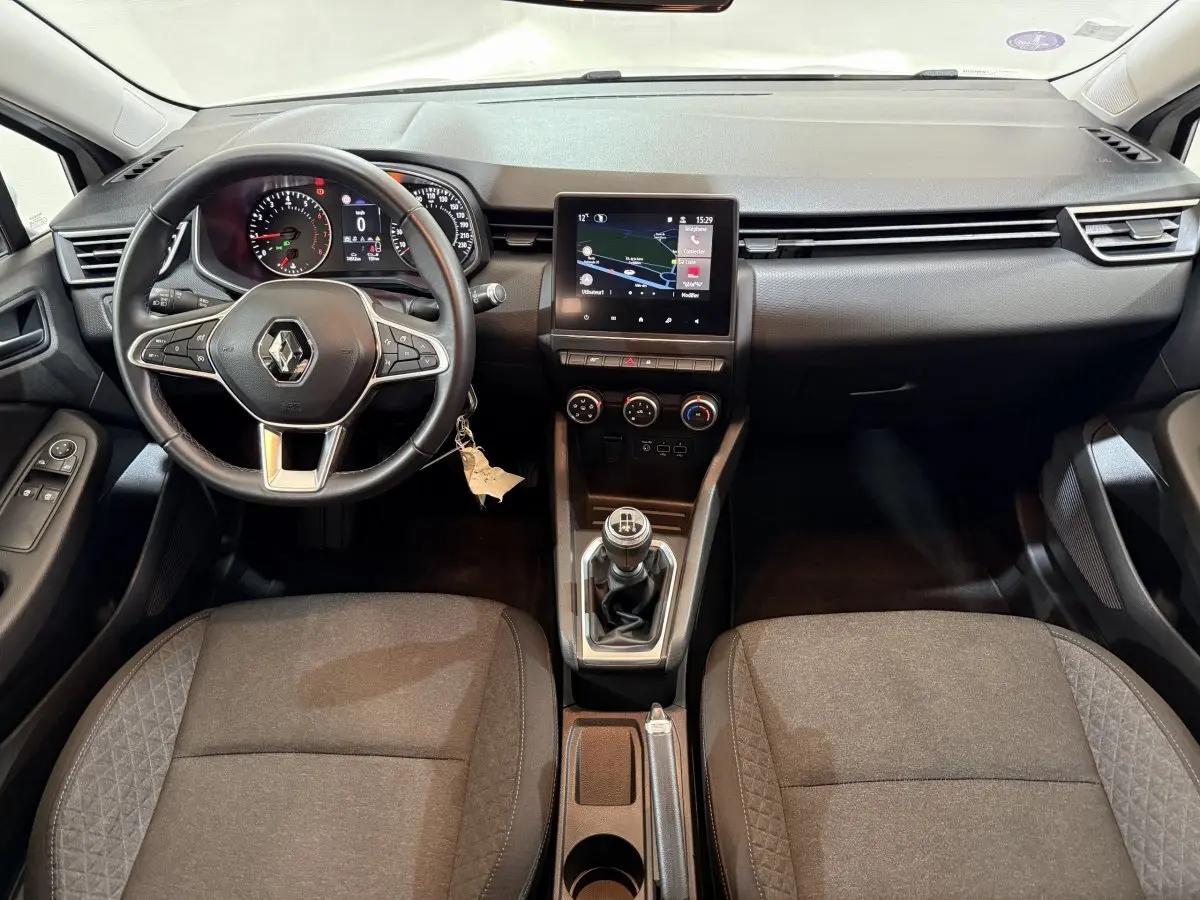 Vue intérieure avant de la Renault Clio Business 2021, tableau de bord noir avec écran tactile central et volant multifonctions cuir synthétique.