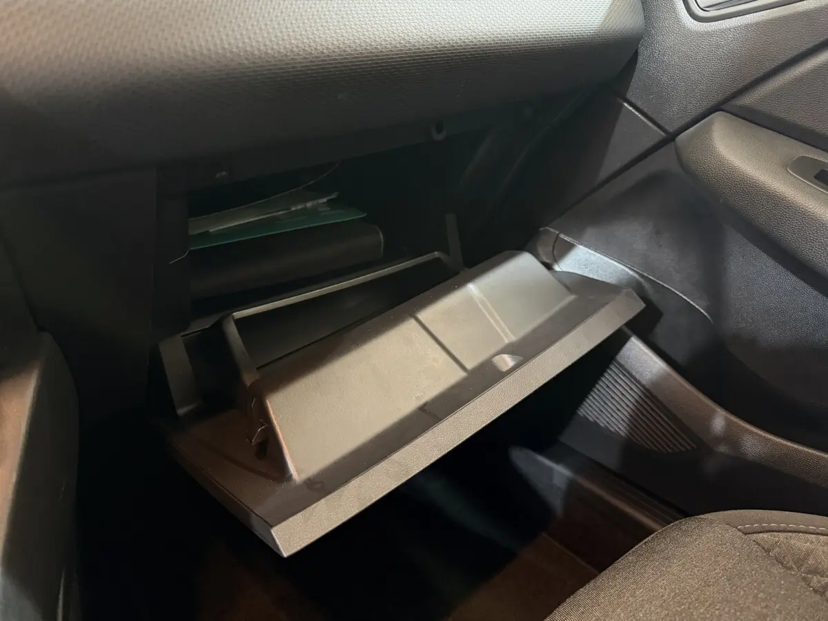 Vue intérieure côté passager de la boîte à gants ouverte dans une Renault Clio Business blanche de 2021.