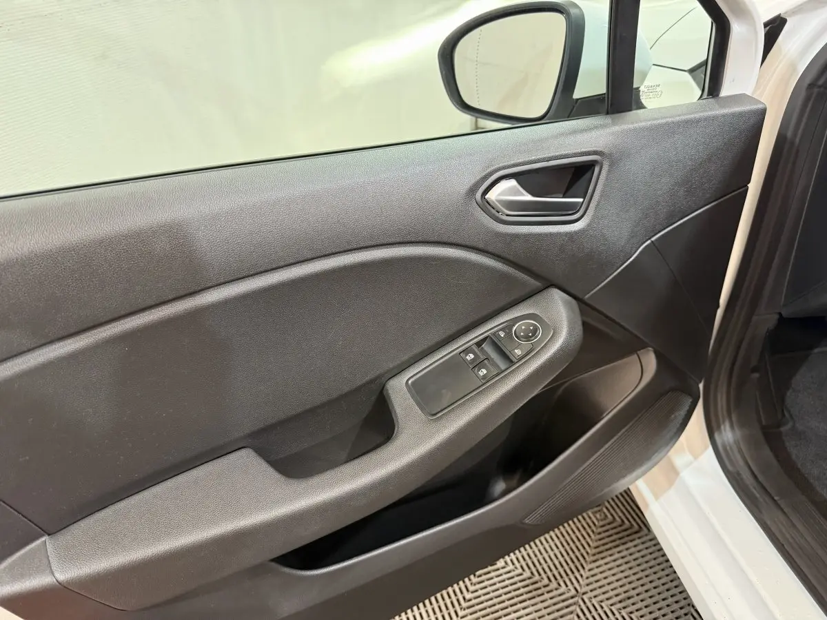 Vue rapprochée de la porte avant gauche noire de la Renault Clio Business blanche, avec commandes de vitres et rétroviseur.
