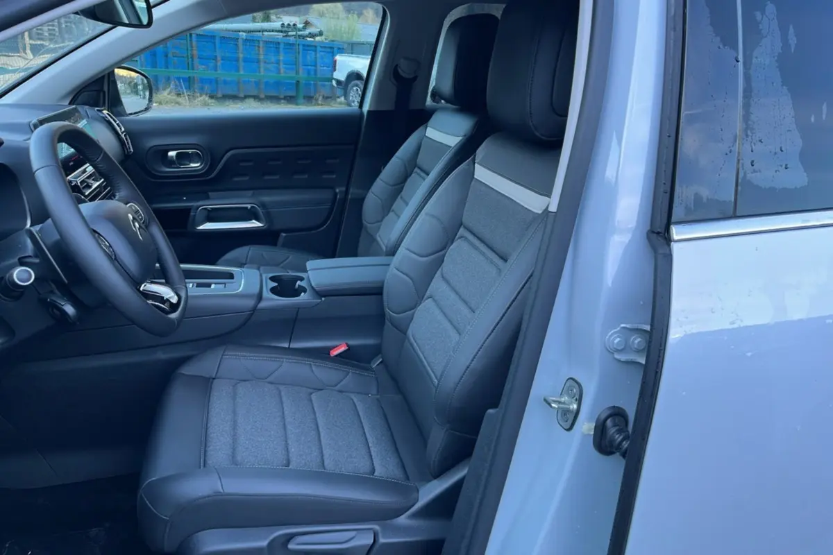 Vue intérieure côté conducteur du Citroën C5 Aircross blanc okénite, mettant en valeur les sièges advanced comfort et le volant cuir.