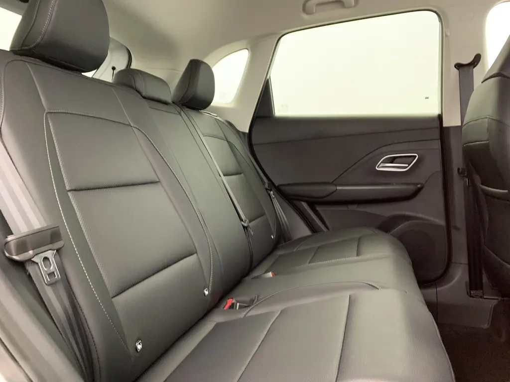Vue latérale droite de l'intérieur arrière du MG ZS 1.5 L Hybrid+ 2026, sièges en similicuir noir avec ceintures visibles.