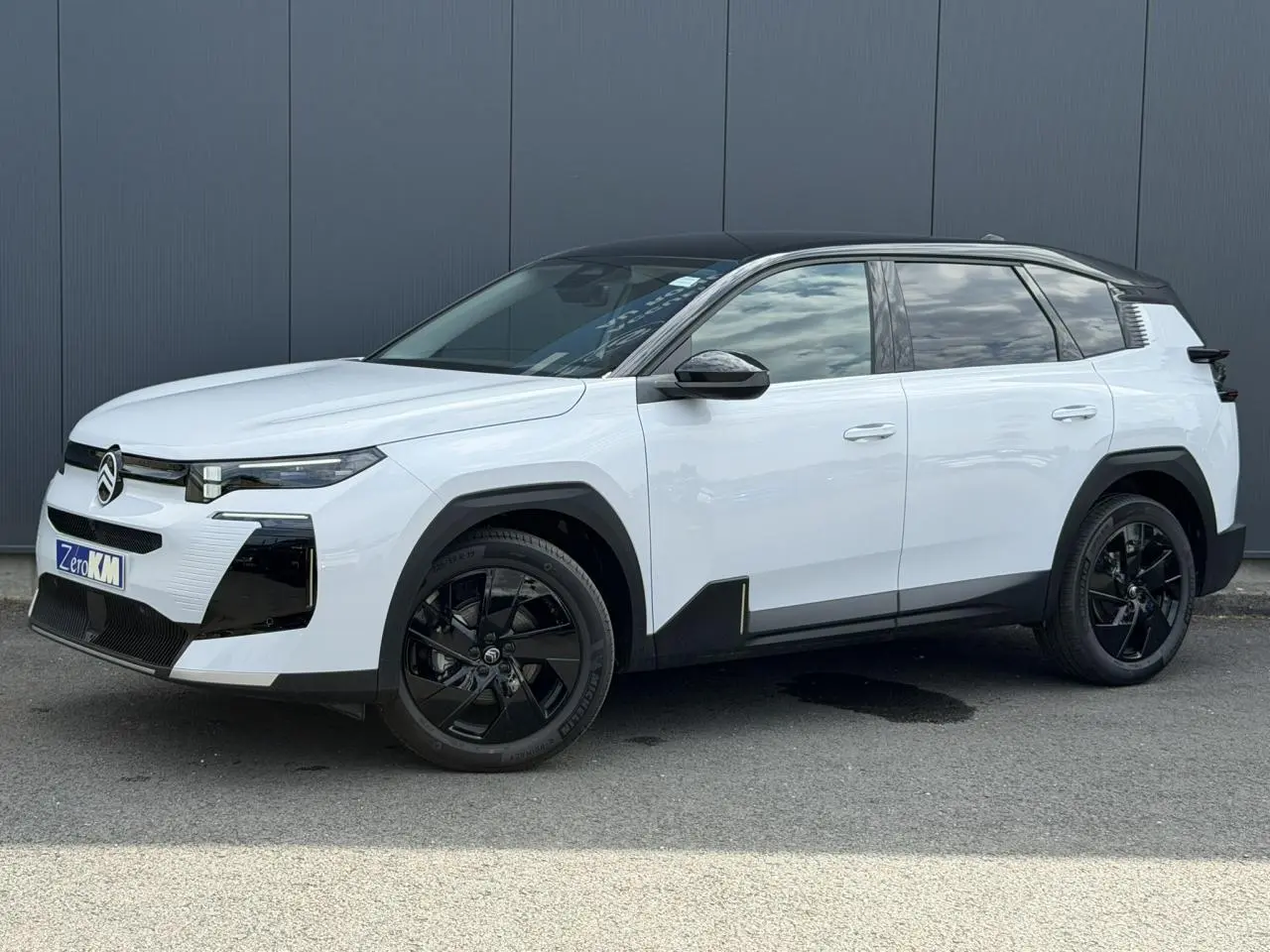 Citroën C5 Aircross blanc Okenite avec toit noir, vue 3/4 avant droit, jantes alliage noires et détails noirs contrastants.