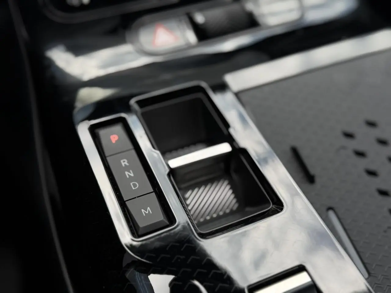 Gros plan sur la console centrale noire brillante du Citroën C5 Aircross hybride avec sélecteur de vitesses électronique.