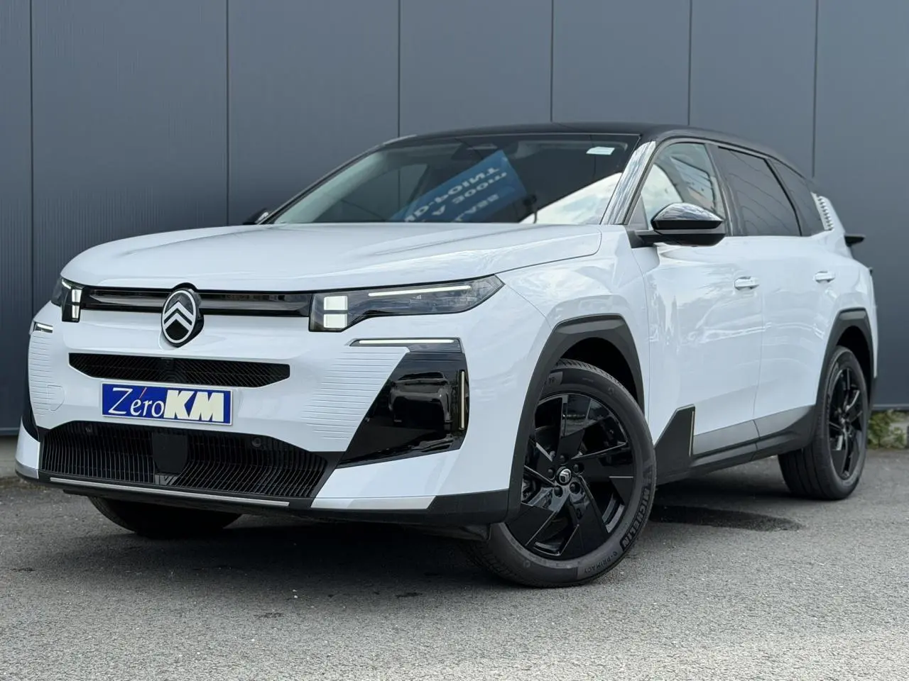 Citroën C5 Aircross blanc Okenite avec toit noir, vue 3/4 avant mettant en valeur ses optiques LED et jantes noires.